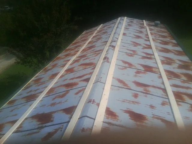 Rusted metal roof panels with new wood purlins before replacement — Storm Damage Roof Repair in Holmesville by Roofing Brothers