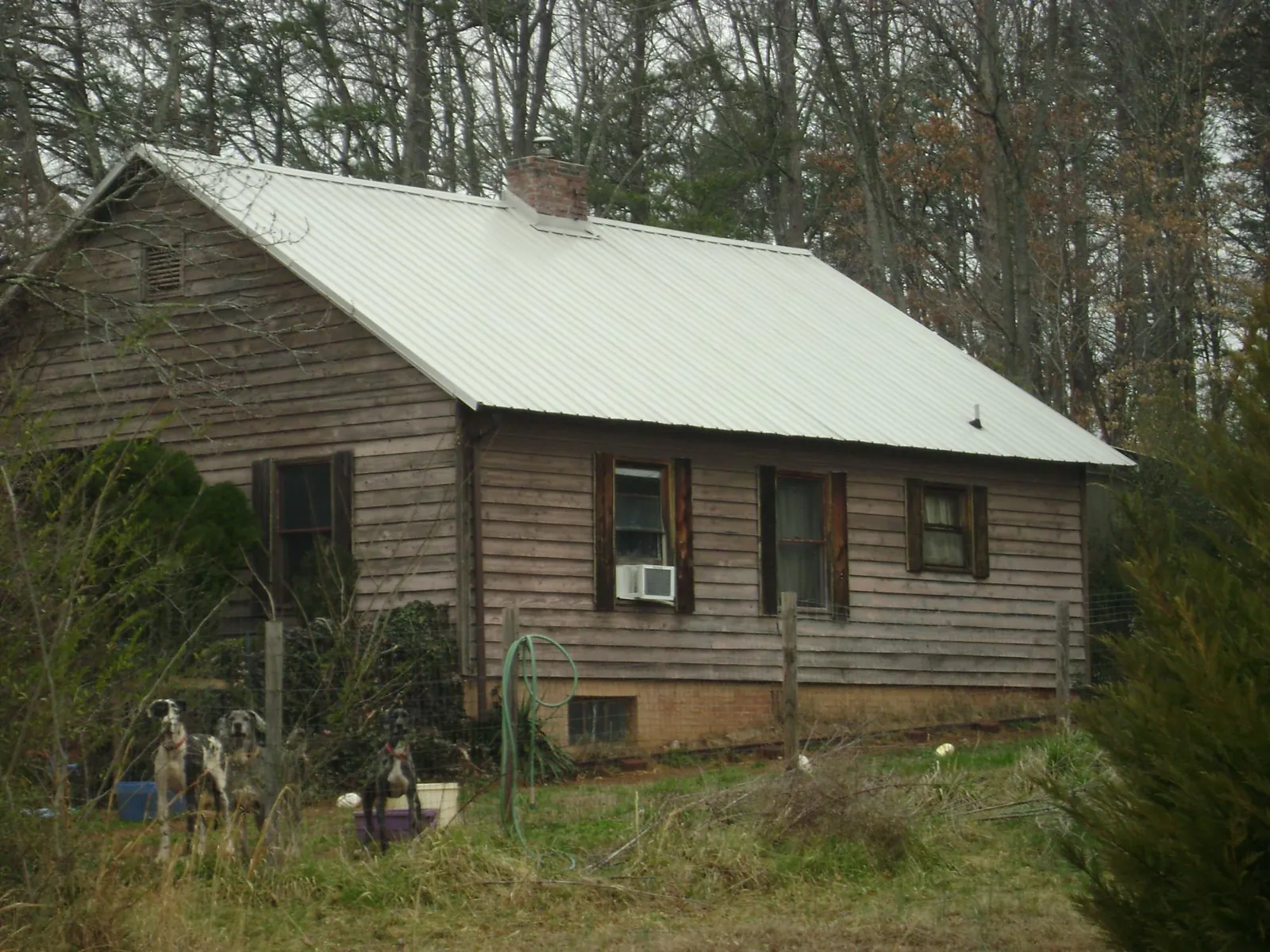 White metal roof on an old wood sided farmhouse, from a Metal Roof Installation job in Holmesville